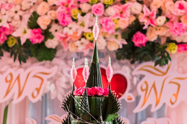 Close-up of Phan Bai Sri, or Baai Sri Tray, made of banana leaves and flowers and blurred the background.