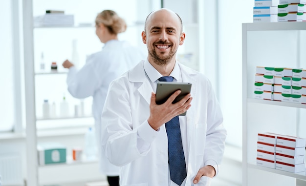 Close-up. pharmacist with a digital tablet looking at you.