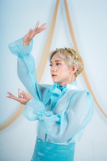 Close up photo of an Asian woman with short blonde hair and wearing a blue dress