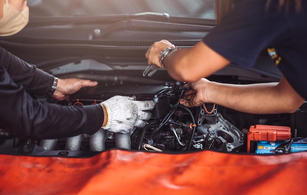 Close up photo of auto mechanic worker working in garage
workshop car engine repair service by professional