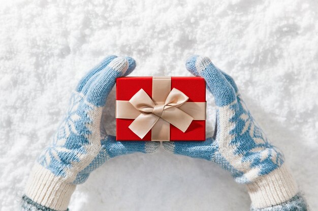 Photo close-up photo background of holding gift box in snow