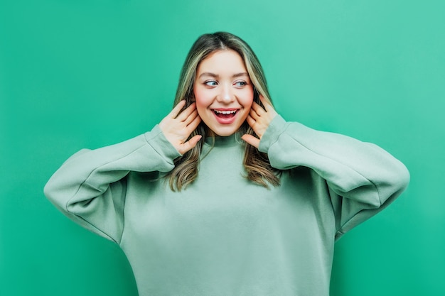 Close up photo of a beautiful girl on green shouting about sales