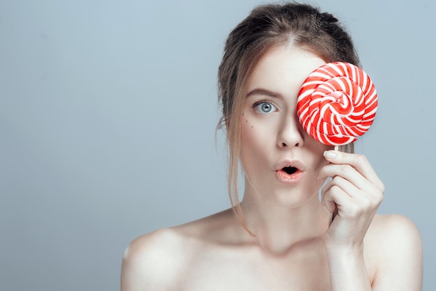 Close-up photo of a beautiful girl with a lollipop.