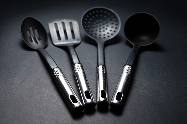 Close-up photo of black plastic kitchen utensils with chromed handles.