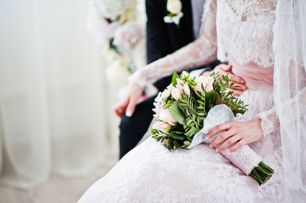 Foto del primo piano di un mazzo in mani della sposa.