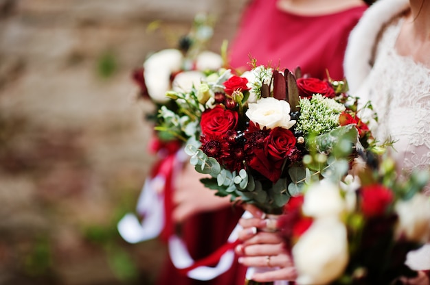 Close-up photo of bridesmaids and bride holding bouquets in their hands.