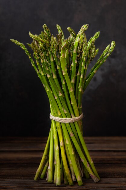 Close up photo Bunch of fresh green asparagus on wooden background.