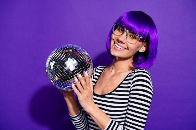 Close up photo of charming youth holding mirror ball smiling isolated over violet purple background