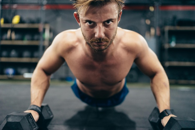 Close up photo of a concentrated man doing pushups