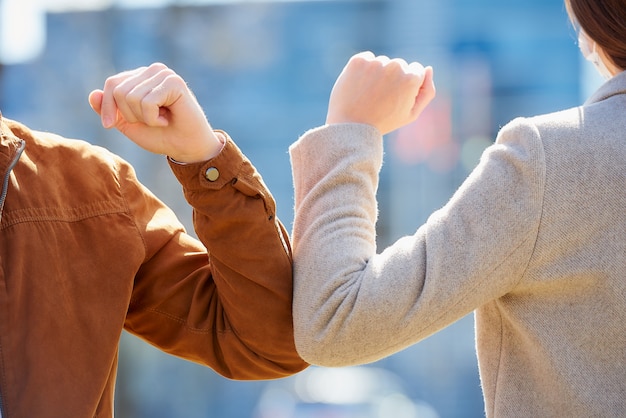 Photo a close-up photo of elbow bumping. elbow greeting to avoid the spread of coronavirus