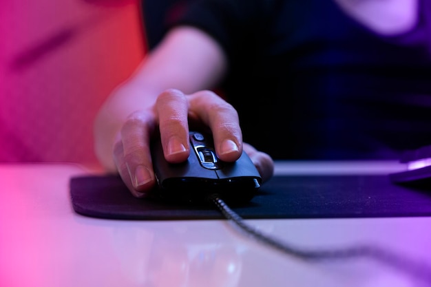 セレクティブ フォーカスでマウスにゲーマーの手の写真を閉じます。サイバー スポーツ ゲーマーがマウスをクリックします。