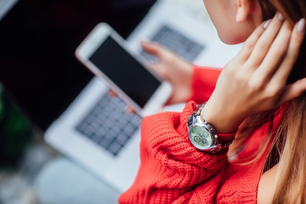 Close up photo. Girl with laptop and phone doing shopping online. Details.