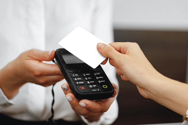 Primo piano foto della mano del cliente che paga con carta di credito contactless