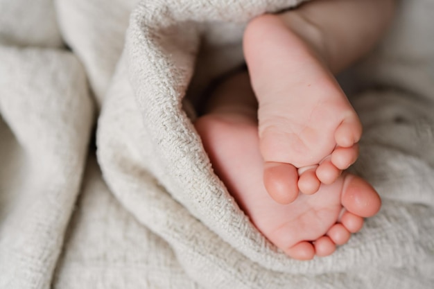 Close up photo of little child barefoot feet on knitted blanket copy space High quality photo