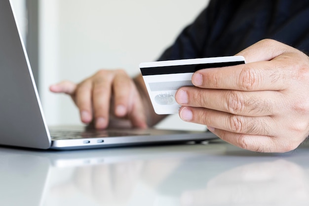 Close up photo of male hands holding credit card. Online shopping concept idea, copy space.