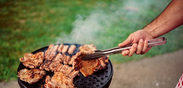 バーベキューで肉を焼く男のクローズアップ写真