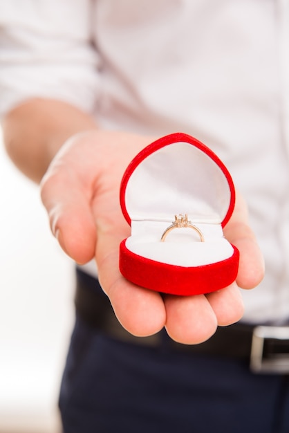 Close up photo of man's hand holding box with wedding ring