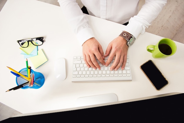 Close up photo of man's hands typing on keyboard