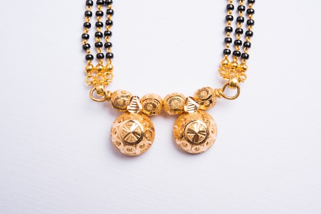 Close-up photo of a Mangalsutra or necklace which is to be worn by a married hindu women over white background