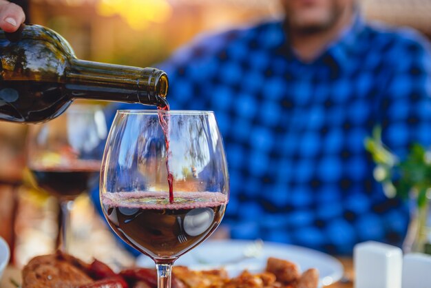 Close up photo of men pouring red wine