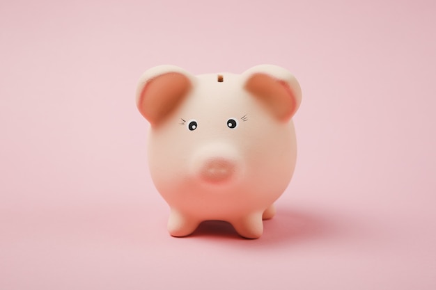 파스텔 핑크색 벽 배경에 격리된 분홍색 돼지 저금통의 사진을 닫습니다. 돈 축적, 투자, 은행 또는 비즈니스 서비스, 부의 개념. 공간 광고를 조롱하십시오.