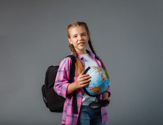 Close up photo portrait of funny cute laughing smart surprised girl holding globe in hands