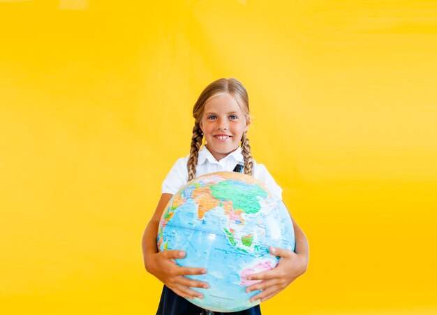 Close up photo portrait of funny cute laughing surprised girl holding globe in hands
