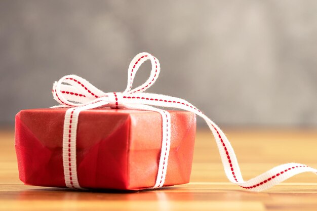 Close up photo of red gift box with white ribbon