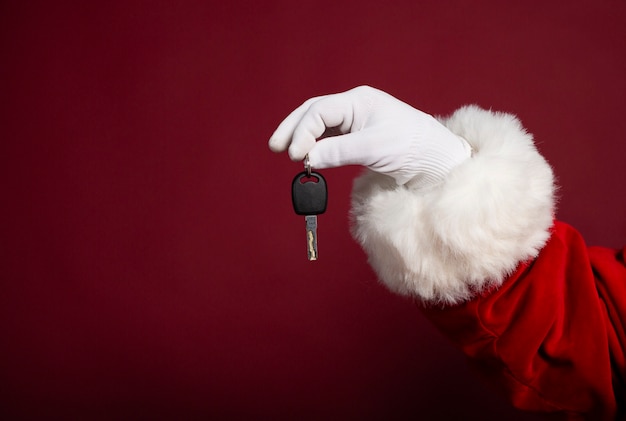 Primo piano foto di babbo natale in mano guanto bianco con una nuova chiave