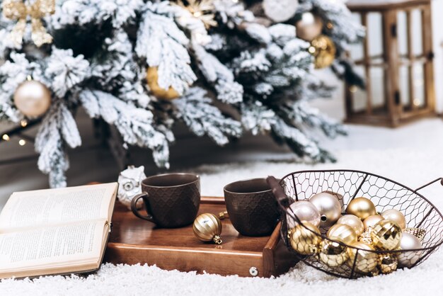 Close-up photo of a tray with two cups of hot drinks and a book