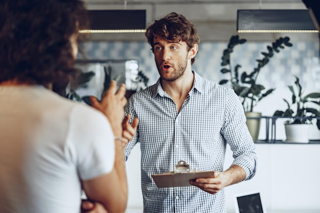 close up photo of two male colleagues discussing project in office