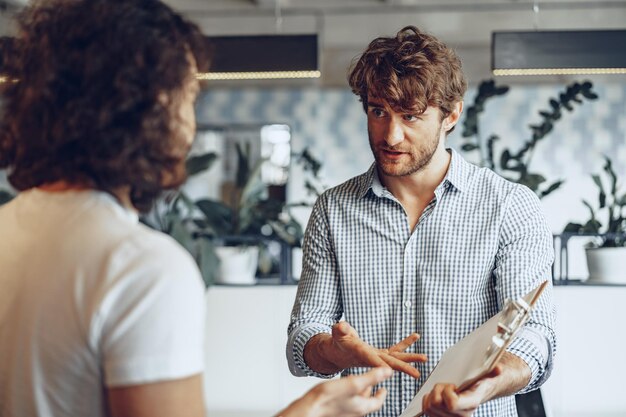 close up photo of two male colleagues discussing project in office