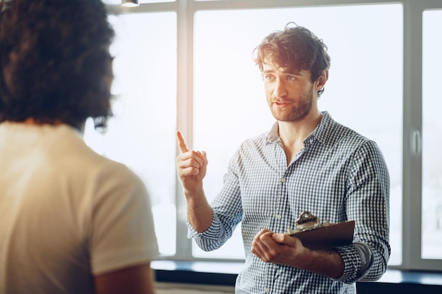 Photo close up photo of two male colleagues discussing project in office