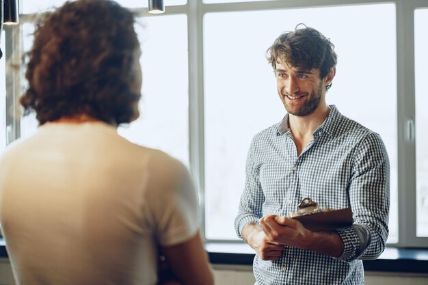 close up photo of two male colleagues discussing project in office