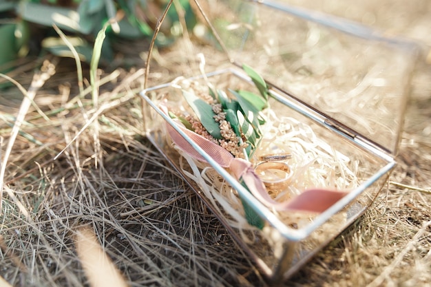 Close up photo of Two wedding gold rings on the background of straw