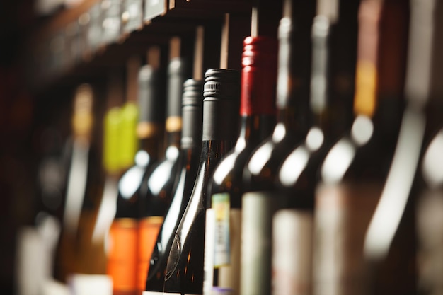 close up photo of various wine on shelf in cellar