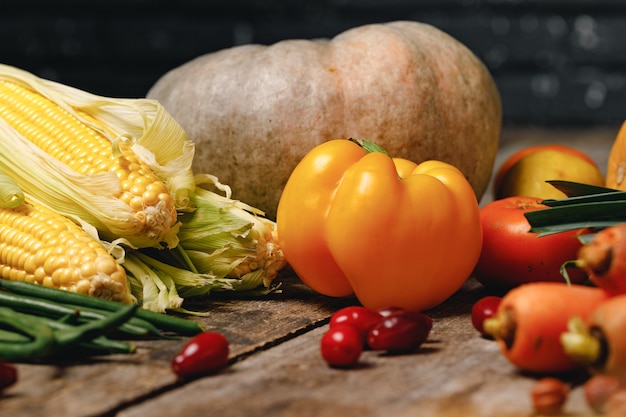 Close up photo of vegetables pumpkins and corn cobs