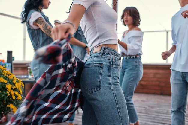 Close up photo of a woman in casual clothes holding checkered shirt behind back while