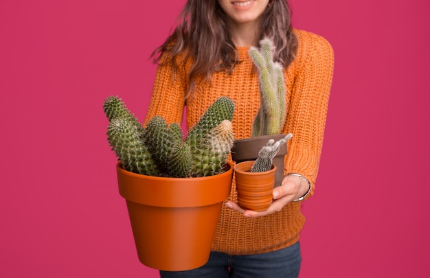 Close up photo of woman holding cactus plants over pink space