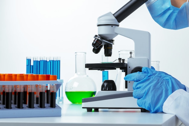 Close up photo of woman scientist working with microscope