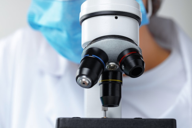 Close up photo of woman scientist working with microscope