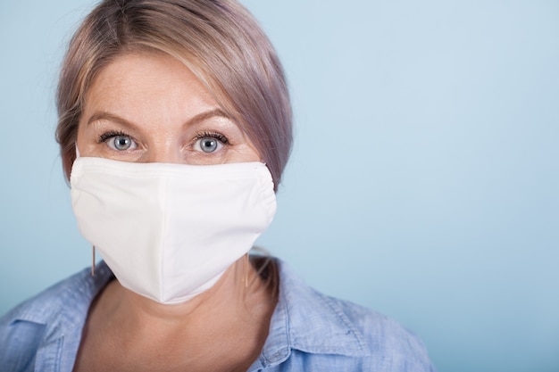 Close up photo of a woman with blonde hair wearing a medical mask