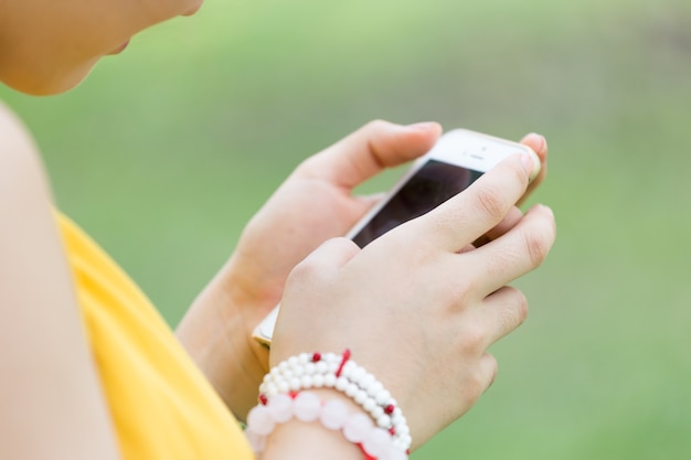 Close up photo of young girl holding and look on screen smartphone