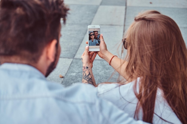 Foto la foto del primo piano di una giovane coppia felice fa un selfie insieme all'aperto.