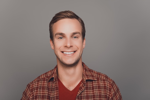 Close up photo of young happy smiling man on gray