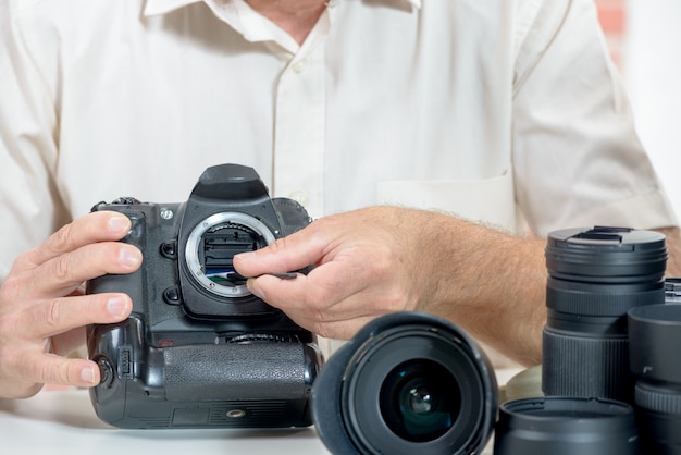 Close up of photographer hand cleaning sensor of his camera