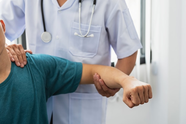 Close-up of a physiotherapist stretching to a man patient at the clinic.