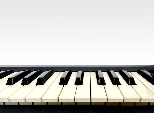 Foto close-up di un pianoforte su sfondo bianco