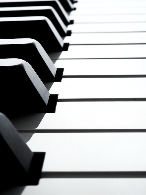 Foto un primo piano di una tastiera di pianoforte tasti in bianco e nero vista laterale