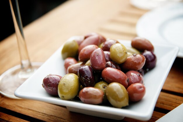 Photo close-up of pickled olives in tray on table